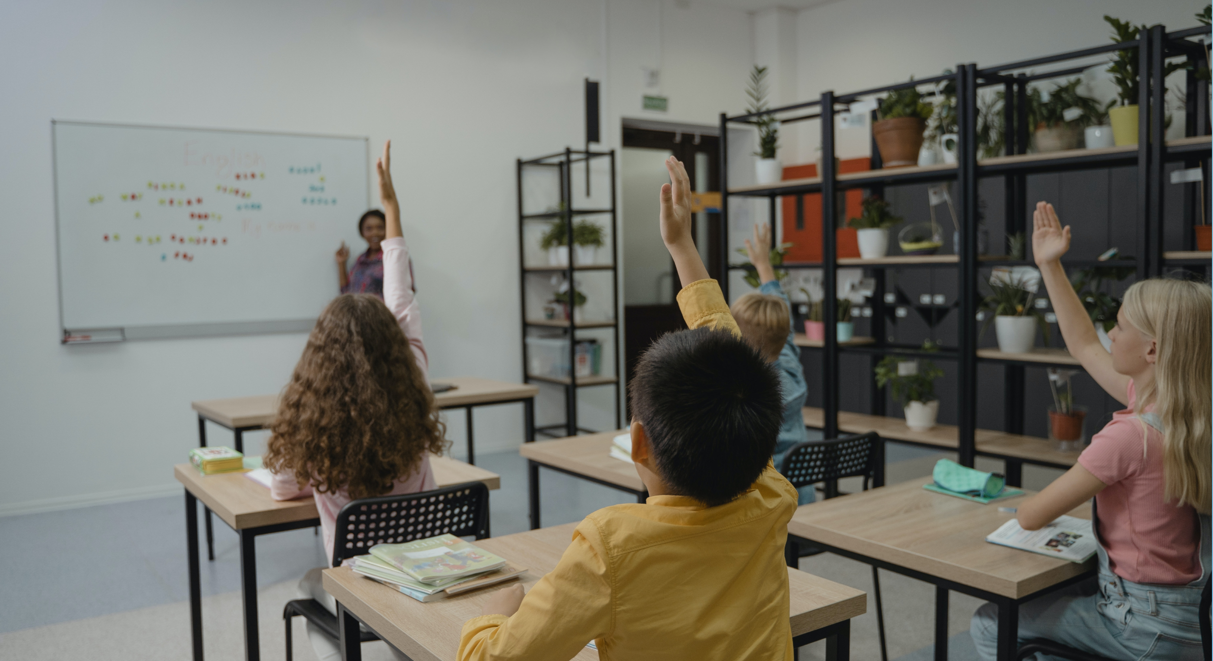 Image of teacher working with kids in a classroom. 