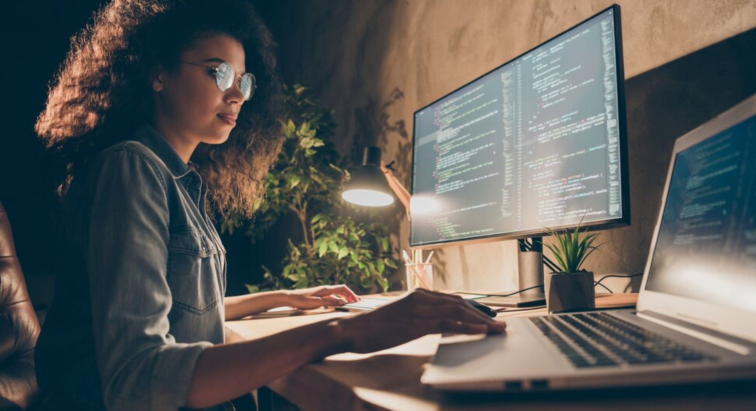 Image of woman working at a computer at her desk. 